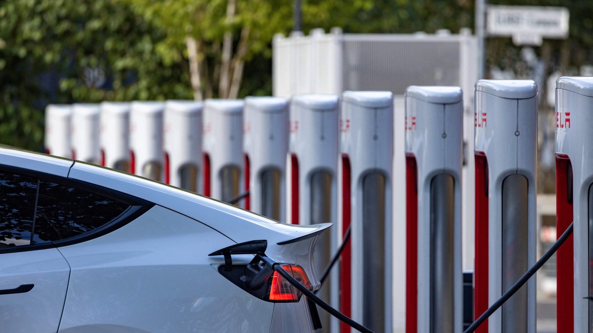 Electric cars plug into a Tesla charging station at an office (File).