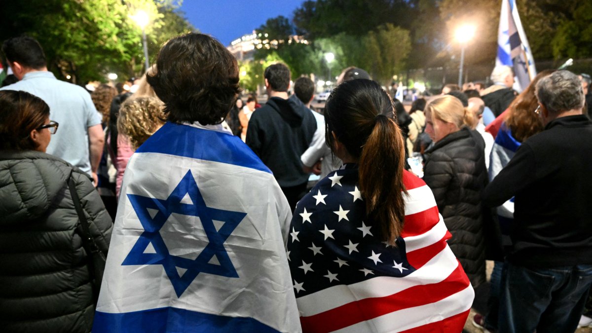 Varias personas asisten a una vigilia tras un tiroteo en el que murieron dos personas.