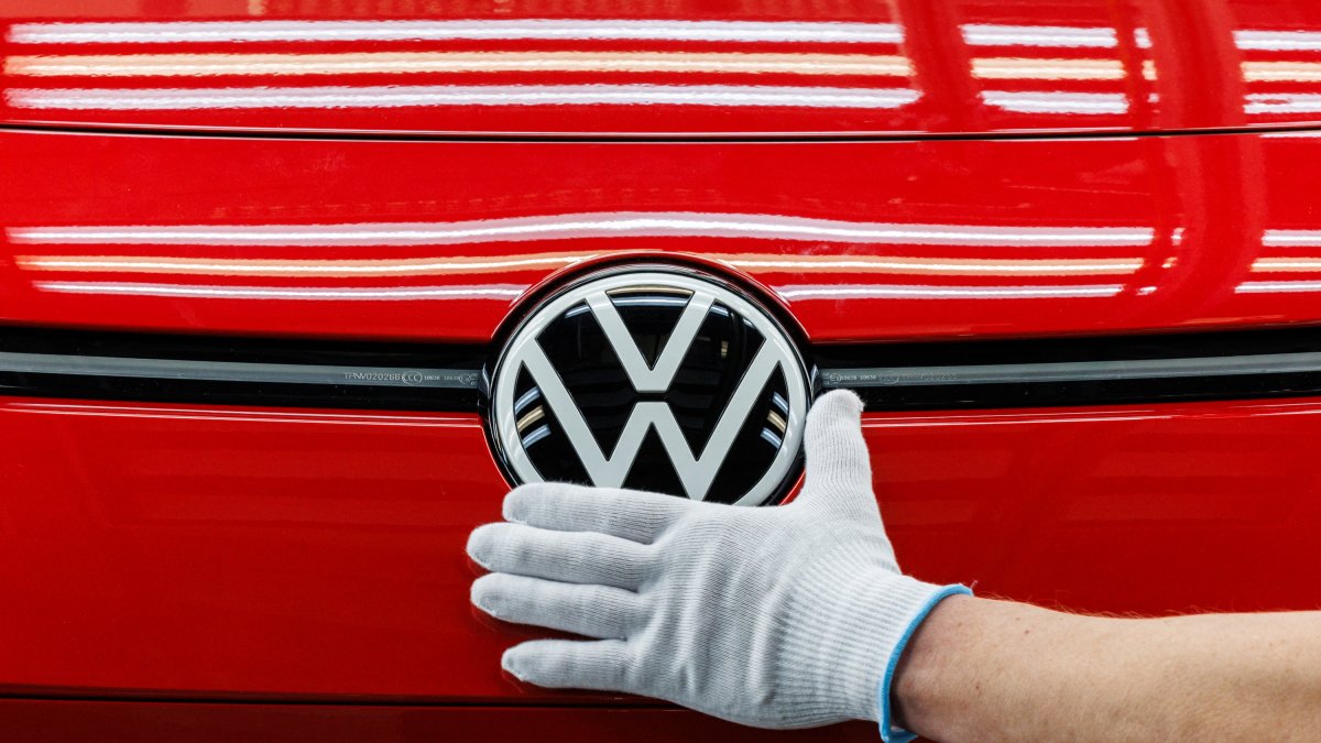 Un empleado prepara un coche en la cadena de montaje del Volkswagen