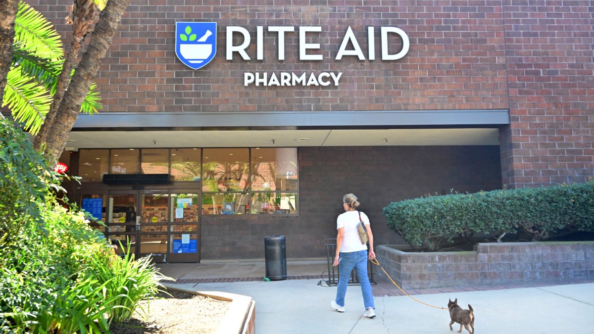 Una mujer entra en una farmacia Rite Aid con su mascota