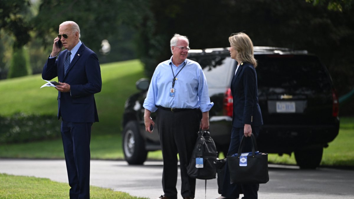 Mike Donilon y Liz Sherwood-Randall, exasesores de Joe Biden, hablando detrás del expresidente