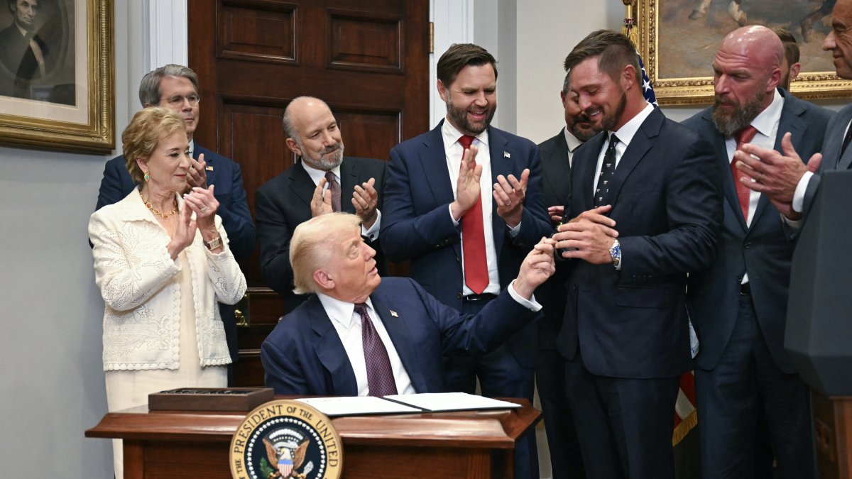 Donald Trump jokes with golfer Bryson DeChambeau during the signing