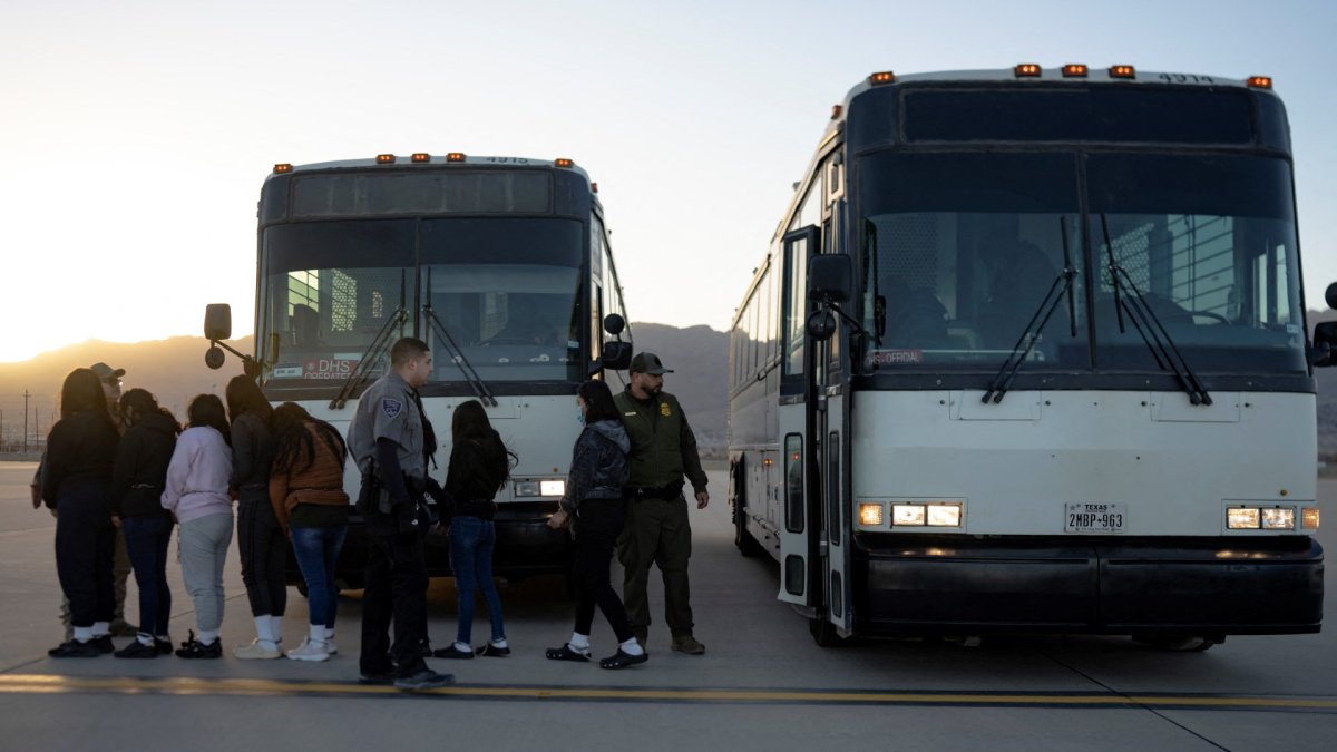 Immigrants get out of a vehicle before boarding a deportation flight at Fort Bliss.