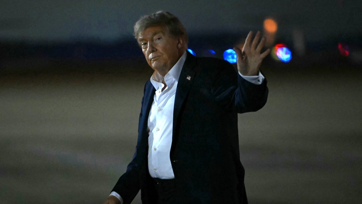 President Donald Trump waves upon his arrival at Joint Base Andrews in Maryland.