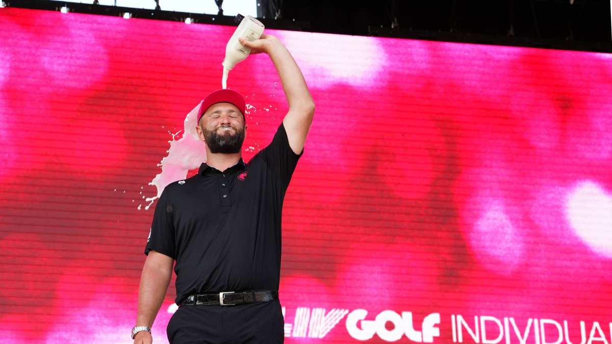 Jon Rahm celebrates victory and pours a bottle of milk over himself.