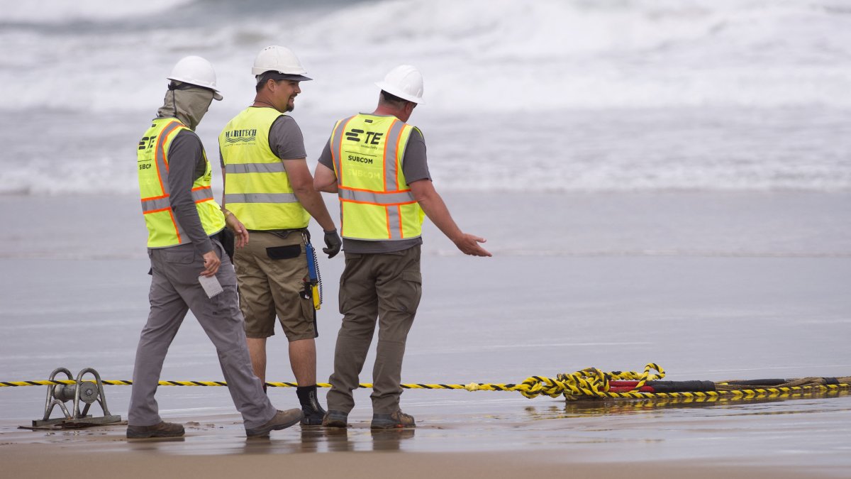 Trabajadores instalan un cable de fibra submarina en una foto de archivo.