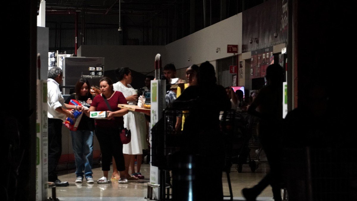People walk inside a shopping mall during a power outage in Cancun, Mexico
