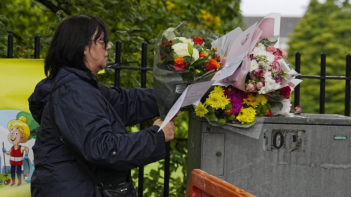 A woman leaves a bouquet of flowers at the vigil for the Manchester victims
