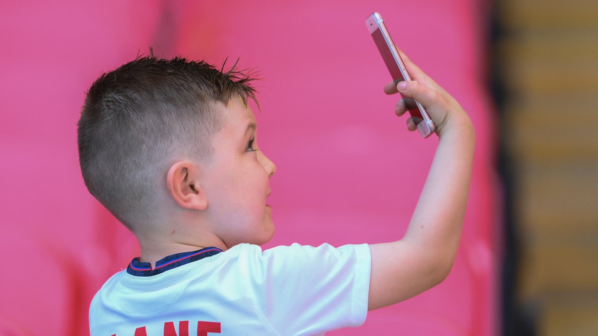 A child takes a selfie with a cell phone
