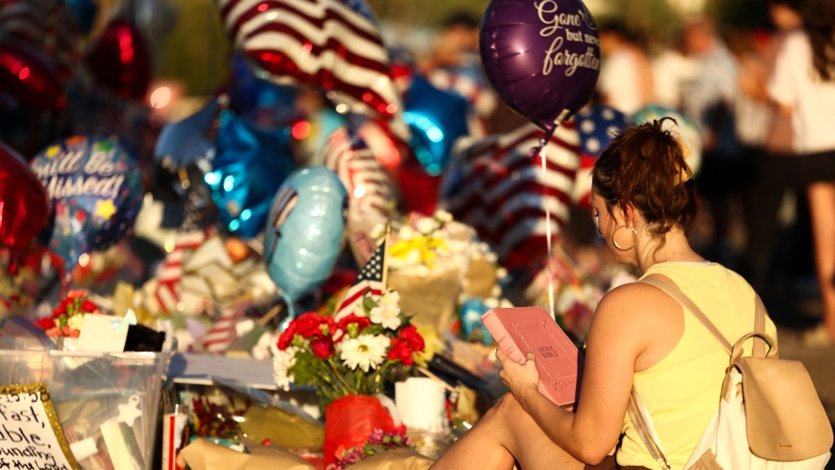 Una joven lee una biblia en el memorial dedicado a Charlie Kirk