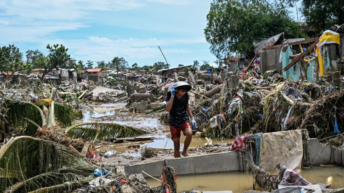 A resident walks among damaged houses after the passage of Typhoon Kalmaegi in Talisay, Cebu province