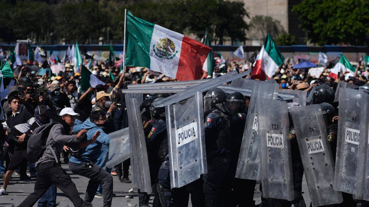 Demonstrators charge at police in Mexico City.