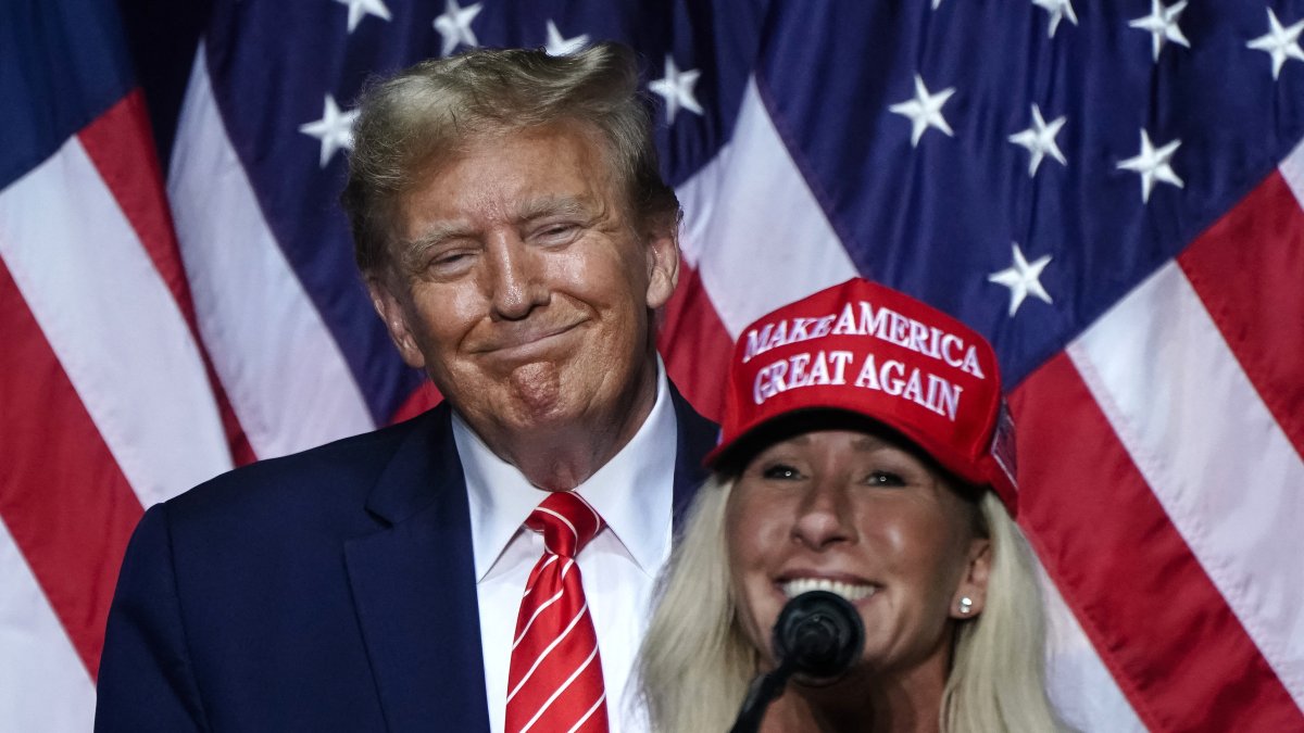 Marjorie Taylor Greene speaking at a rally under the gaze of Donald Trump. File archive
