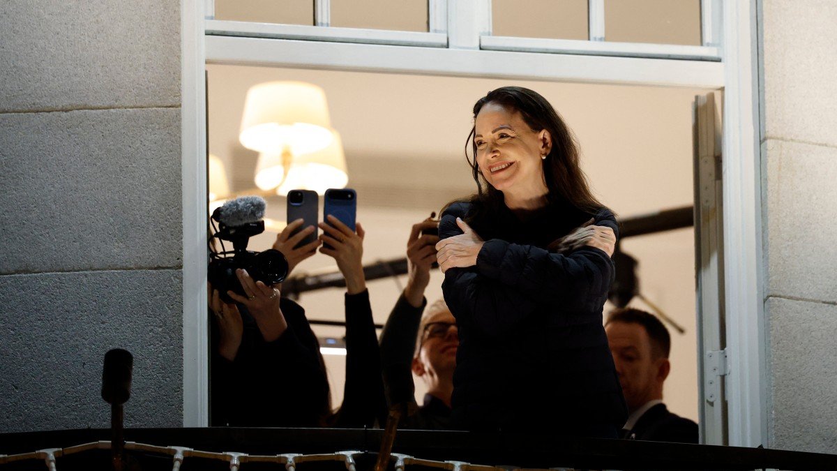 Maria Corina Machado waves to supporters from a balcony of the Grand Hotel in Oslo