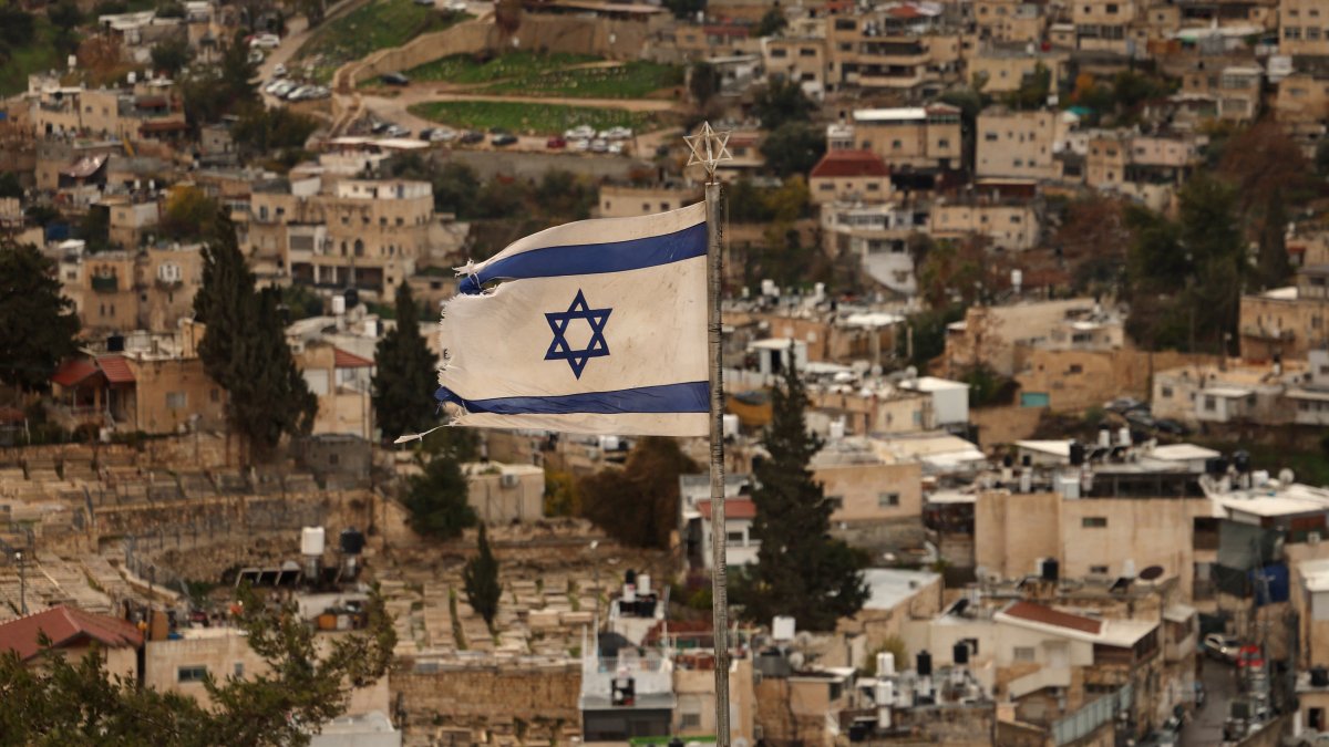 An Israeli flag flutters in the wind over the Arab East Jerusalem neighbourhood of Silwan