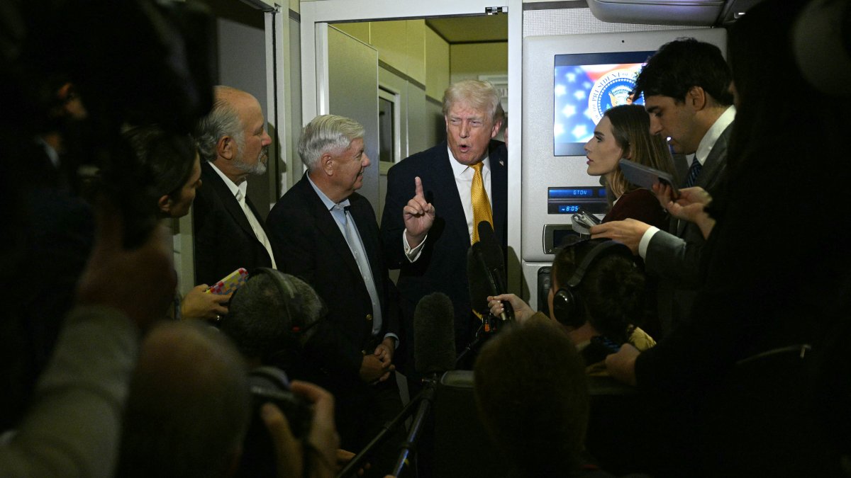 Trump, along with Senator Lindsay Graham, attends to the media on Air Force One.