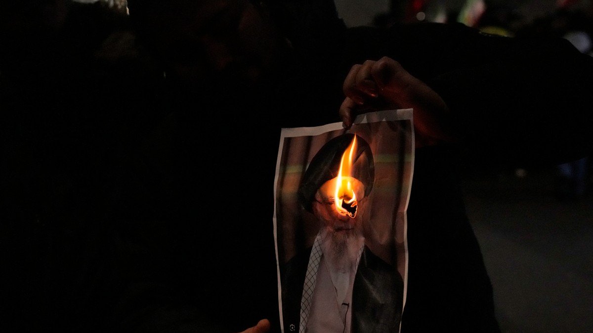 Un manifestante quema una imagen del ayatolá Ali Jamenei