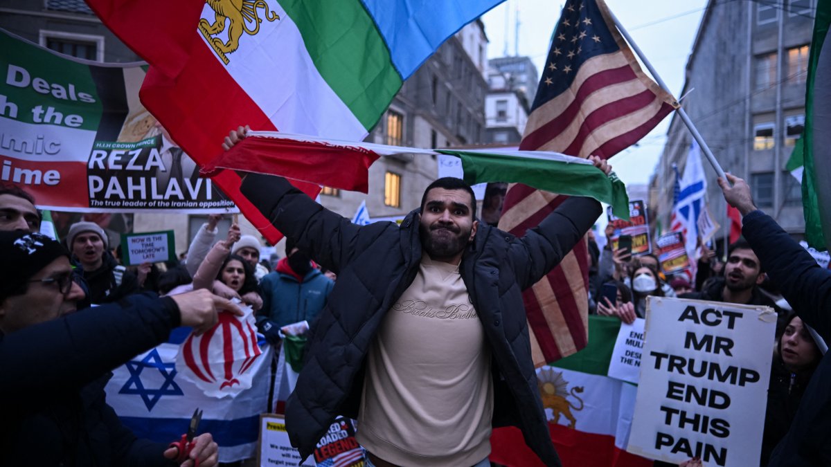 Un manifestante rompe la bandera de la República Islámica de Irán.