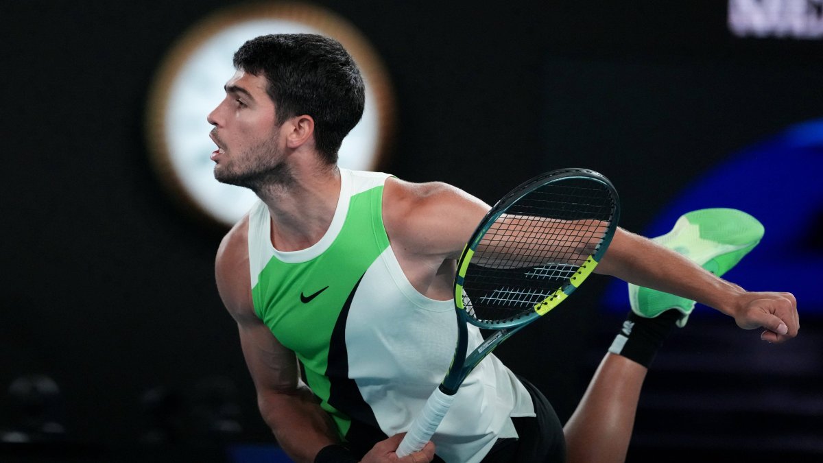 Alcaraz prepares to serve against Alex de Miñaur at the Australian Open.