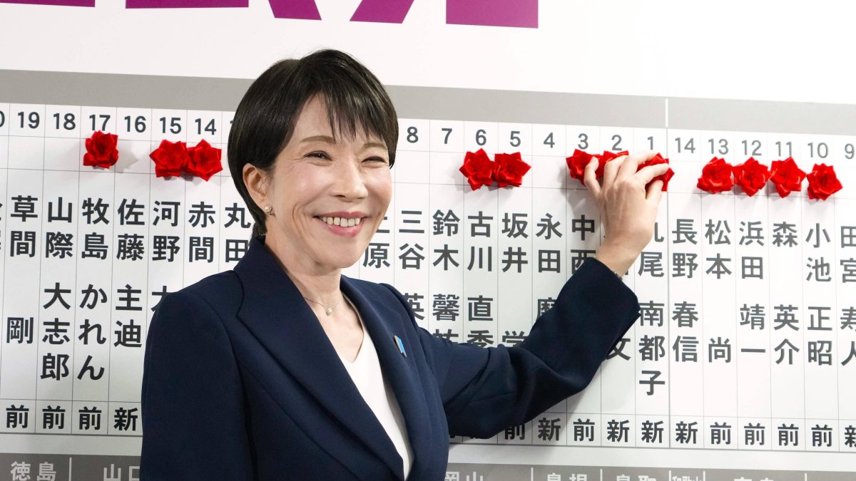 Takaichi places pins with names of winning candidates.