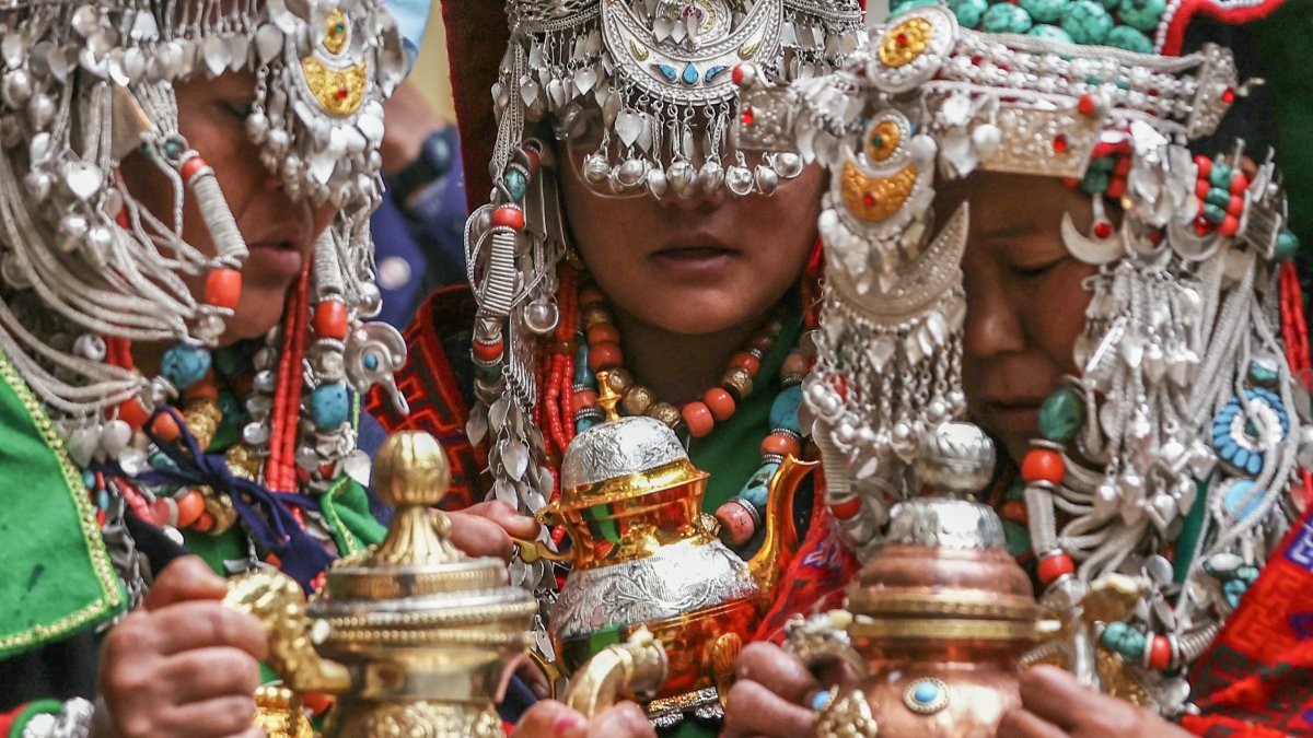 Personas con atuendos tradicionales asisten a la ceremonia de oración del líder espiritual tibetano, el Dalai Lama.