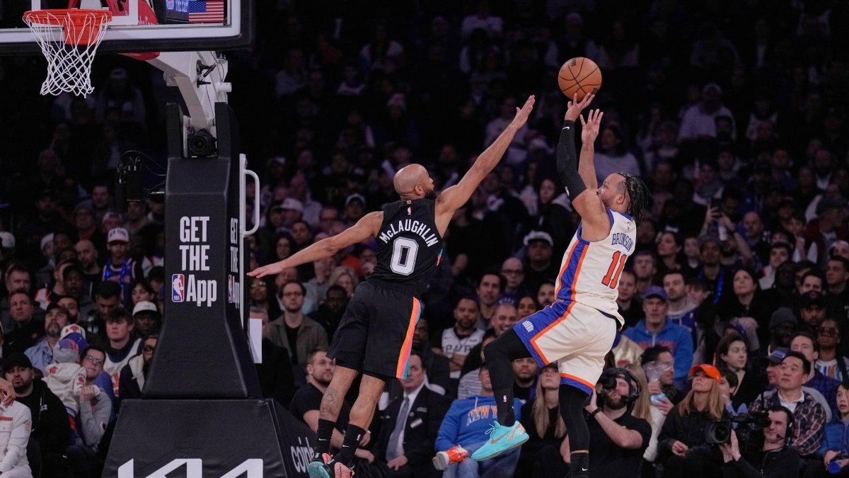 Jalen Brunson, de los New York Knicks, derecha, lanza por encima de Jordan McLaughlin