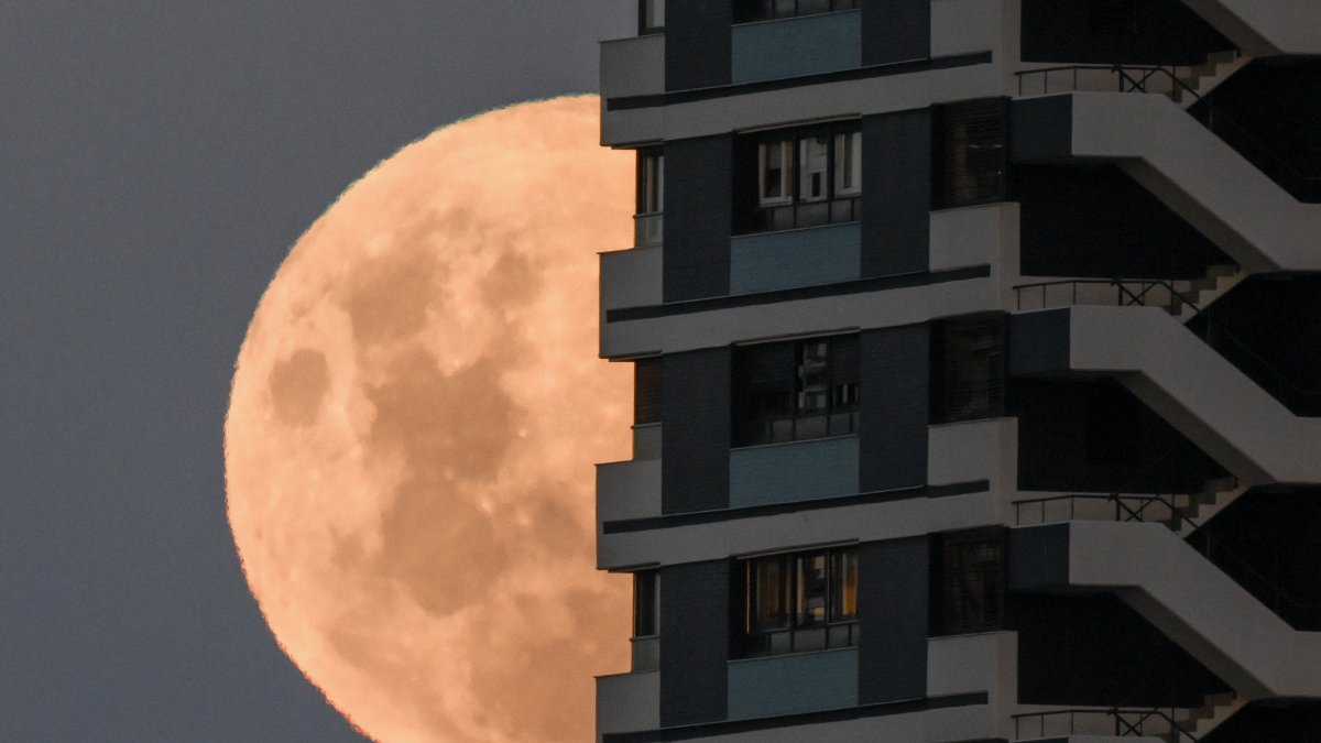The moon rises in its crescent gibbous phase behind a building in Buenos Aires on March 2, 2026.