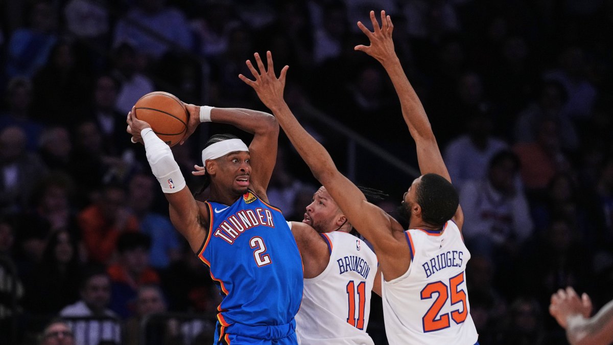 City Thunder's Gilgeous-Alexander protects the ball against Jalen Brunson.