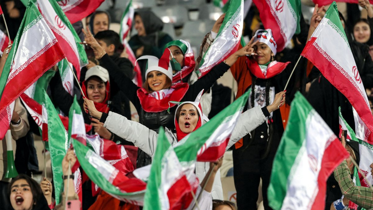 Las aficionadas al fútbol ondean banderas nacionales iraníes mientras animan a su selección (Archivo)