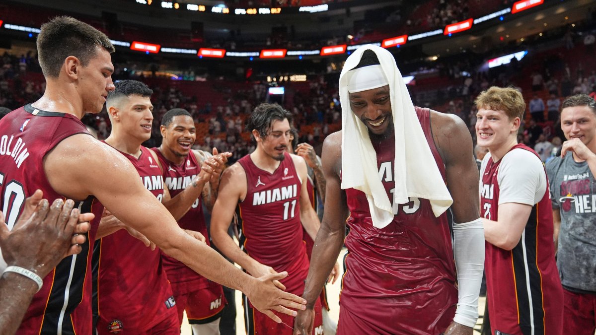 Bam Adebayo, with a towel on his head, congratulated by teammates after scoring 83 points against the Wizards