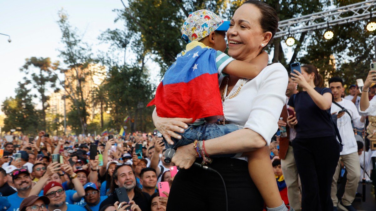 Machado abraza a un niño durante un encuentro con miembros de la comunidad venezolana en Chile