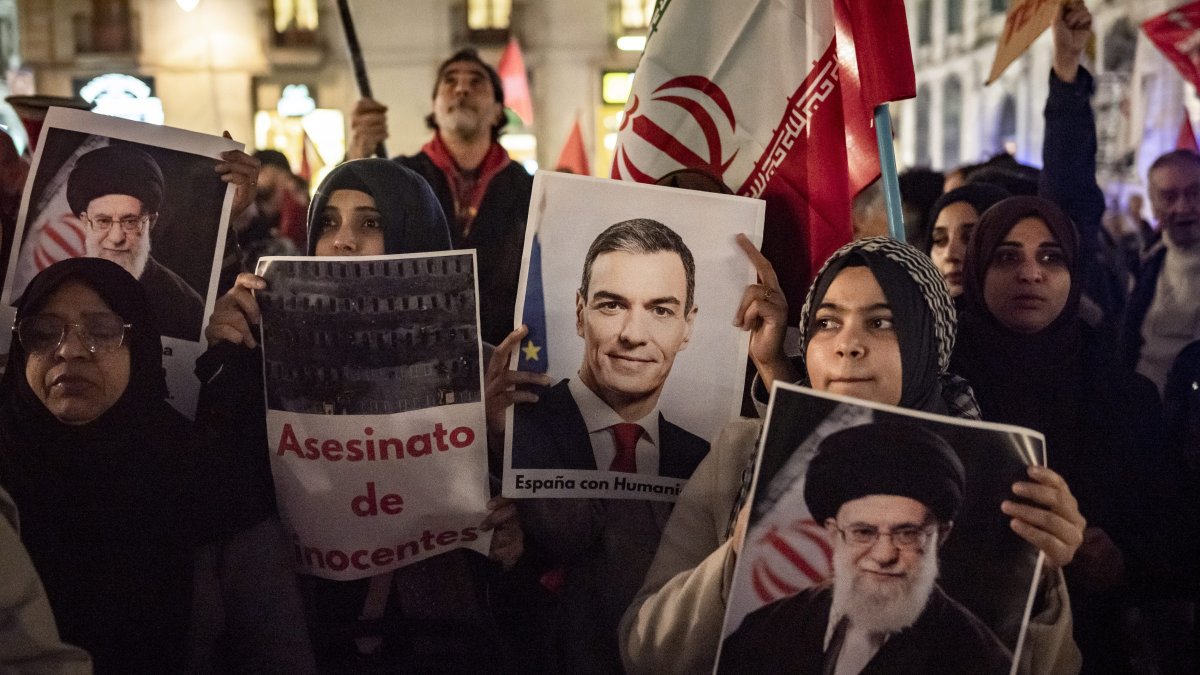 Protesters in Barcelona hold images of Sánchez an Ali Khamenei