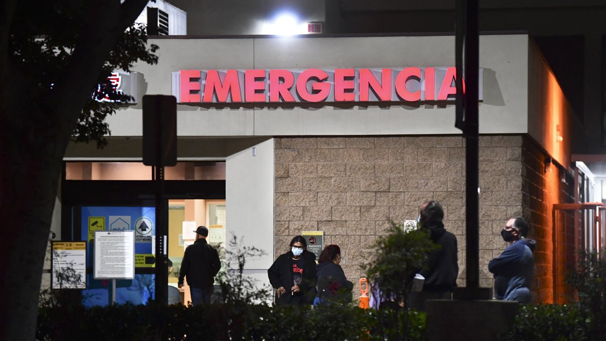 Several people wait outside the emergency room at a hospital (File).