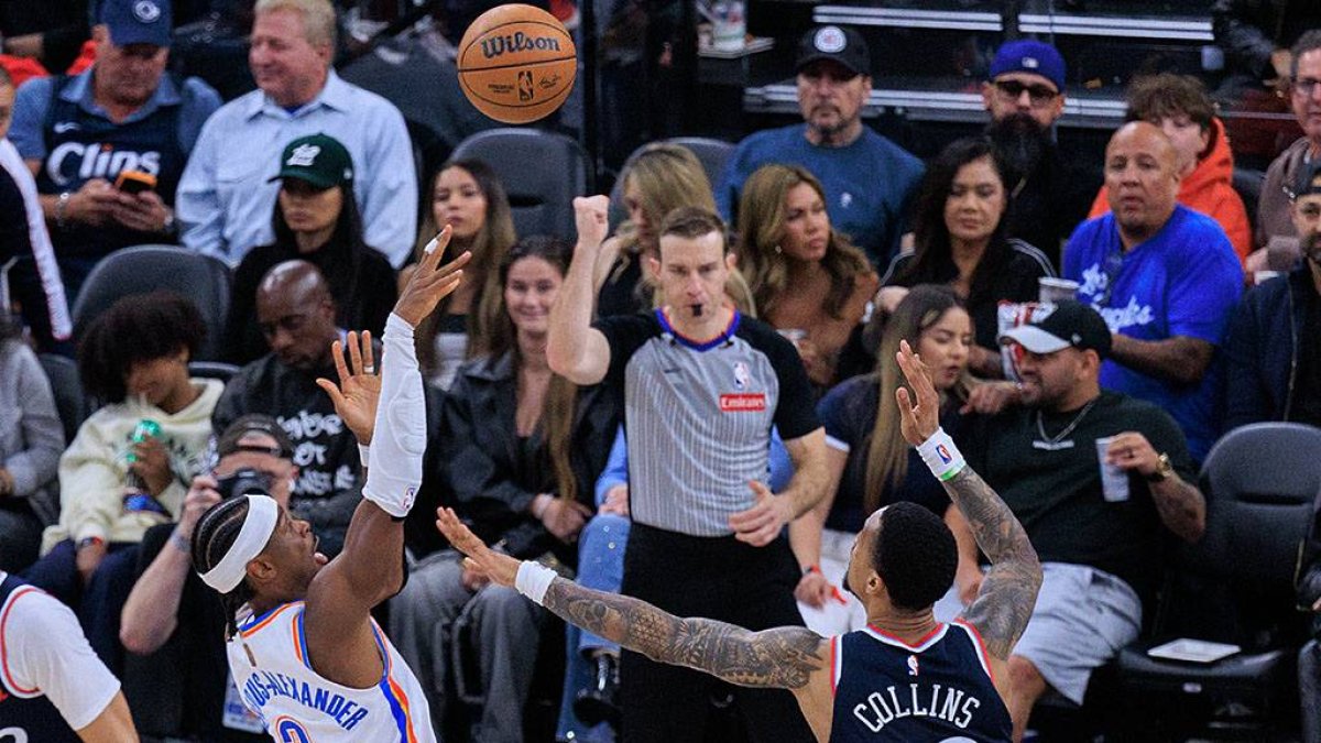 Shai Gilgeous-Alexander drives to the basket in front of Collins.