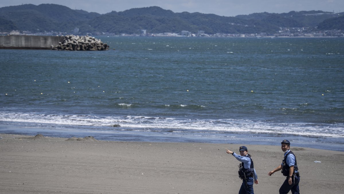 Varios policías ordenan evacuar una playa en Japón en una foto de archivo