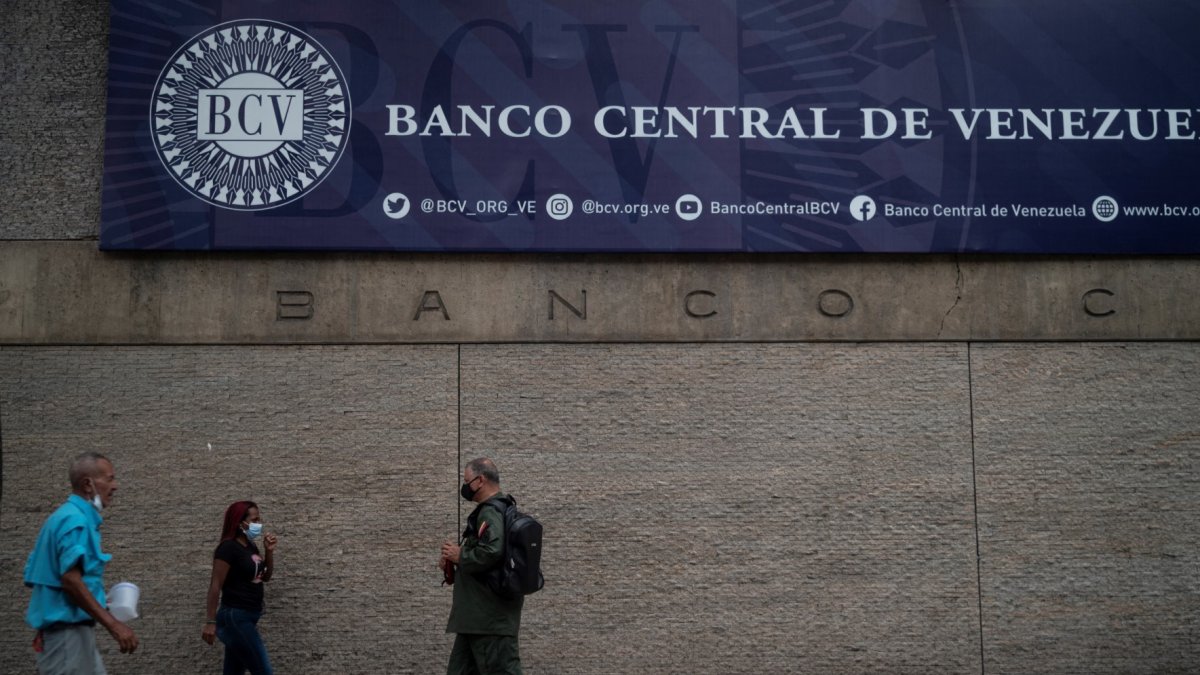 Varias personas caminan frente a la fachada principal del Banco Central de Venezuela en Caracas