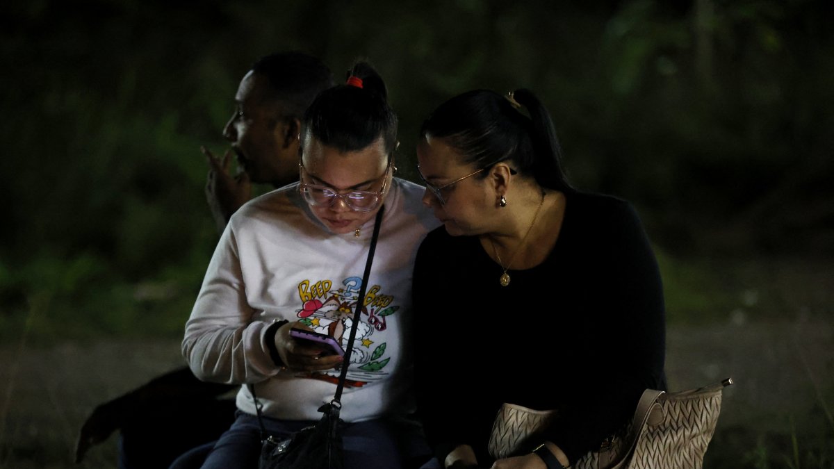 Dos mujeres hispanas con un celular en la mano (Archivo)