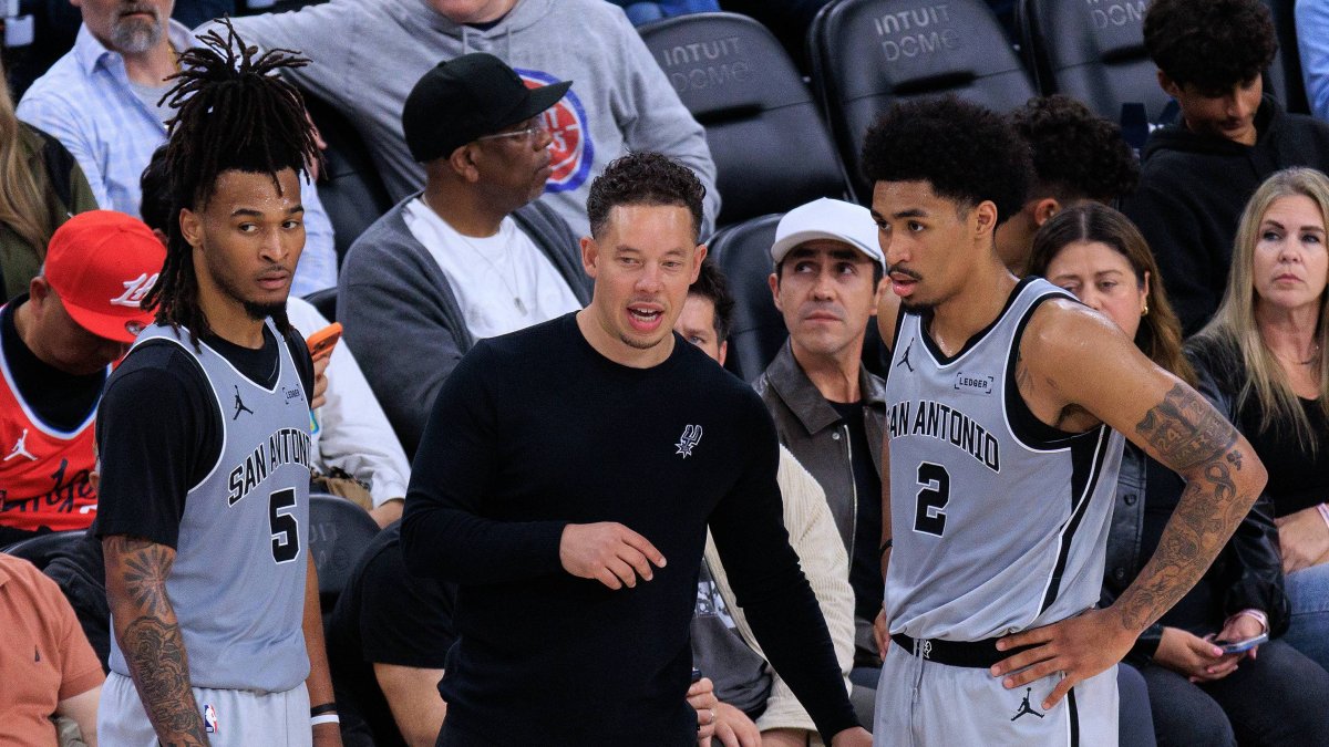 Spurs coach Mitch Johnson talks with Stephon Castle (5) and Dylan Harper (2)