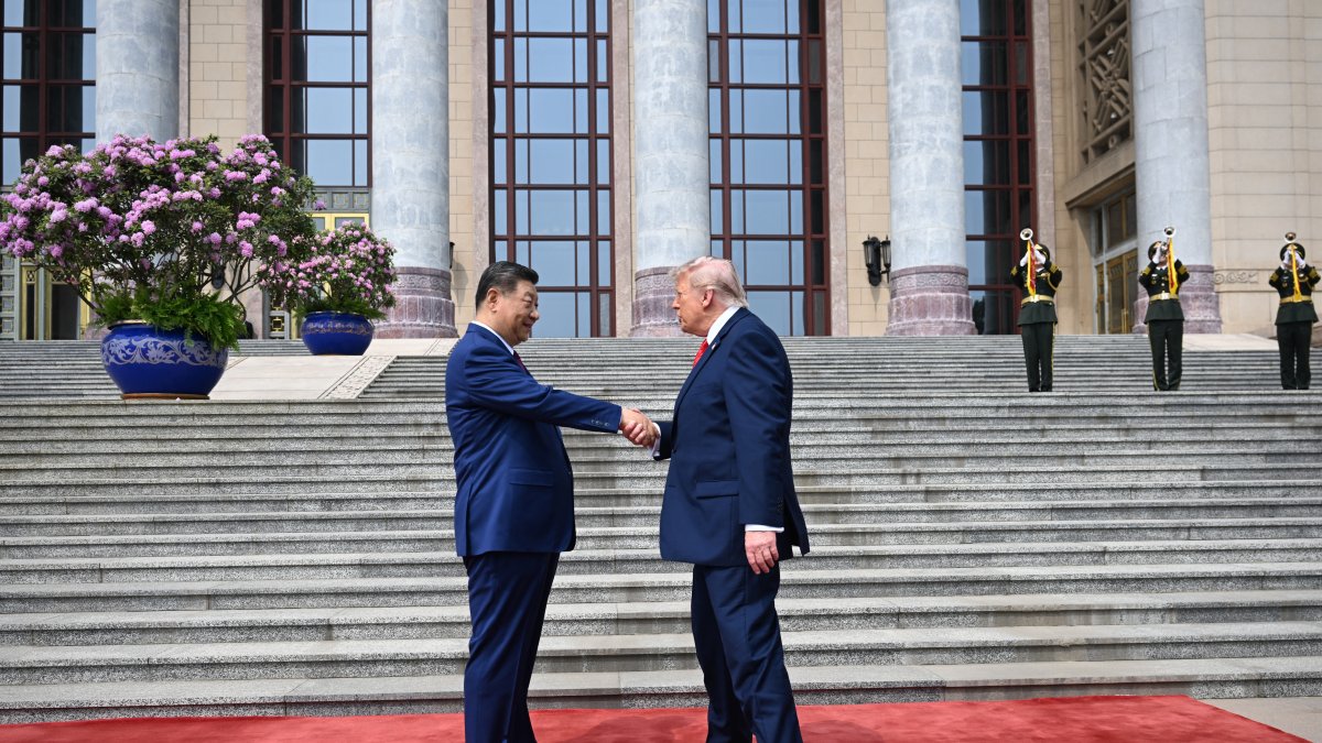 US President Donald Trump (R) shakes hands with China's President Xi Jinping.