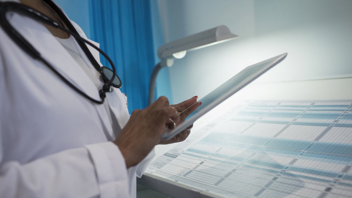 A doctor uses a digital device in the hospital (Stock image).