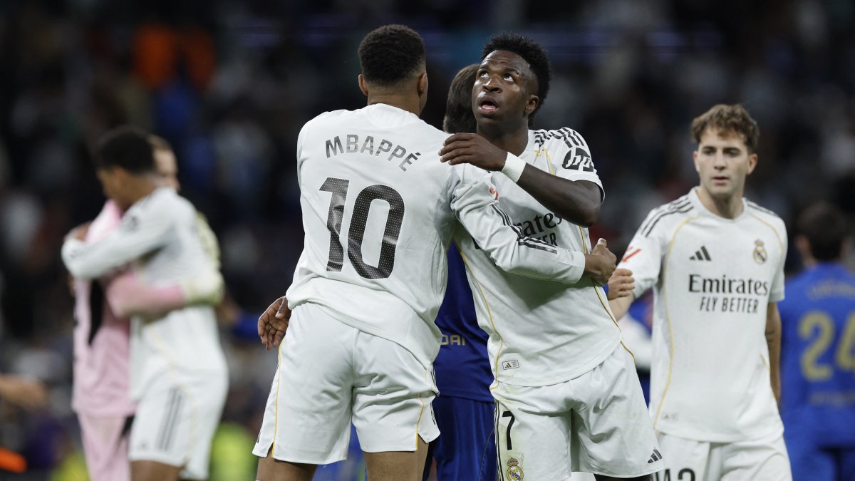 Real Madrid's French forward #10 Kylian Mbappe and Real Madrid's Brazilian forward #07 Vinicius Junior hug each other.
