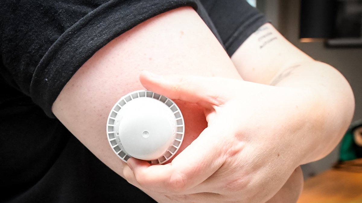 Image shows a glucose sensor applicator on a patient's arm (File).