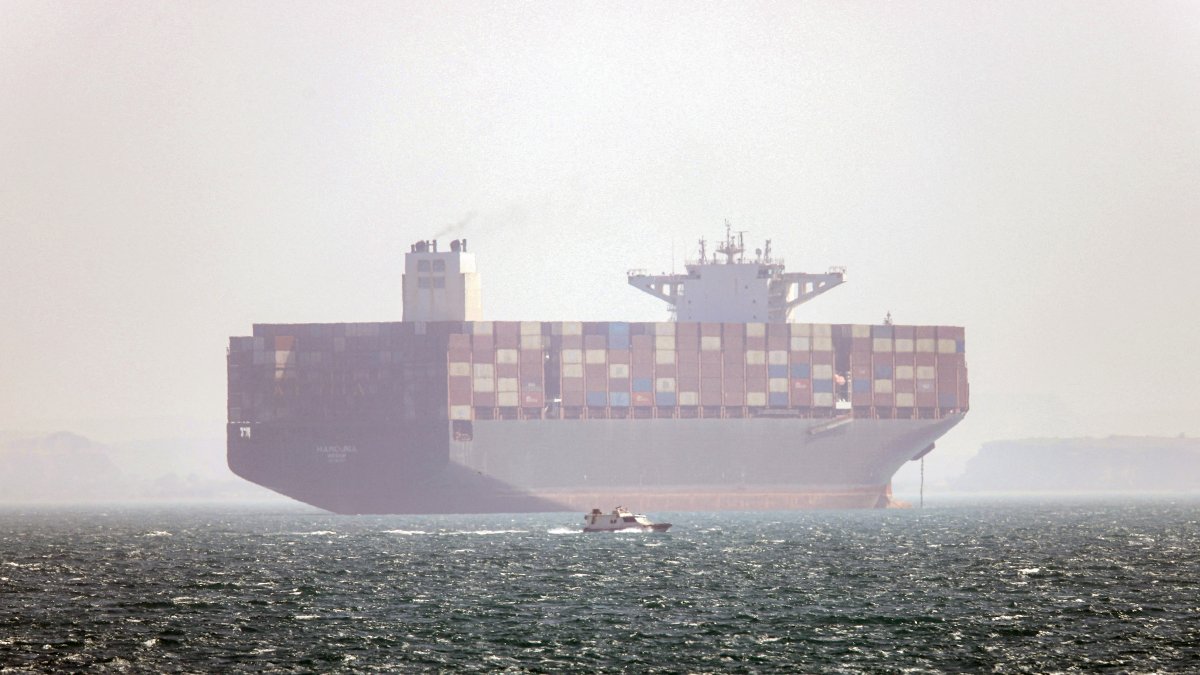 An Iranian vessel at anchor as a small speedboat passes nearby, in the Strait of Hormuz, off Bandar Abbas, southern Iran, May 2, 2026.