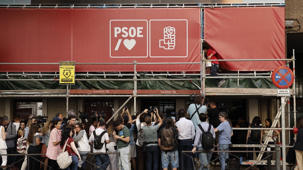 Members of the press crowd in front of the PSOE headquarters while the UCO conducts a search.