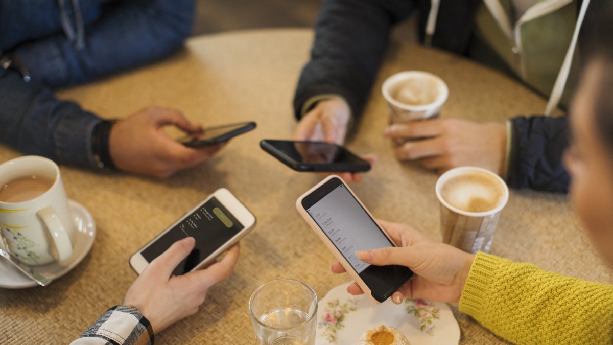Adultos usando sus teléfonos móviles (Archivo)