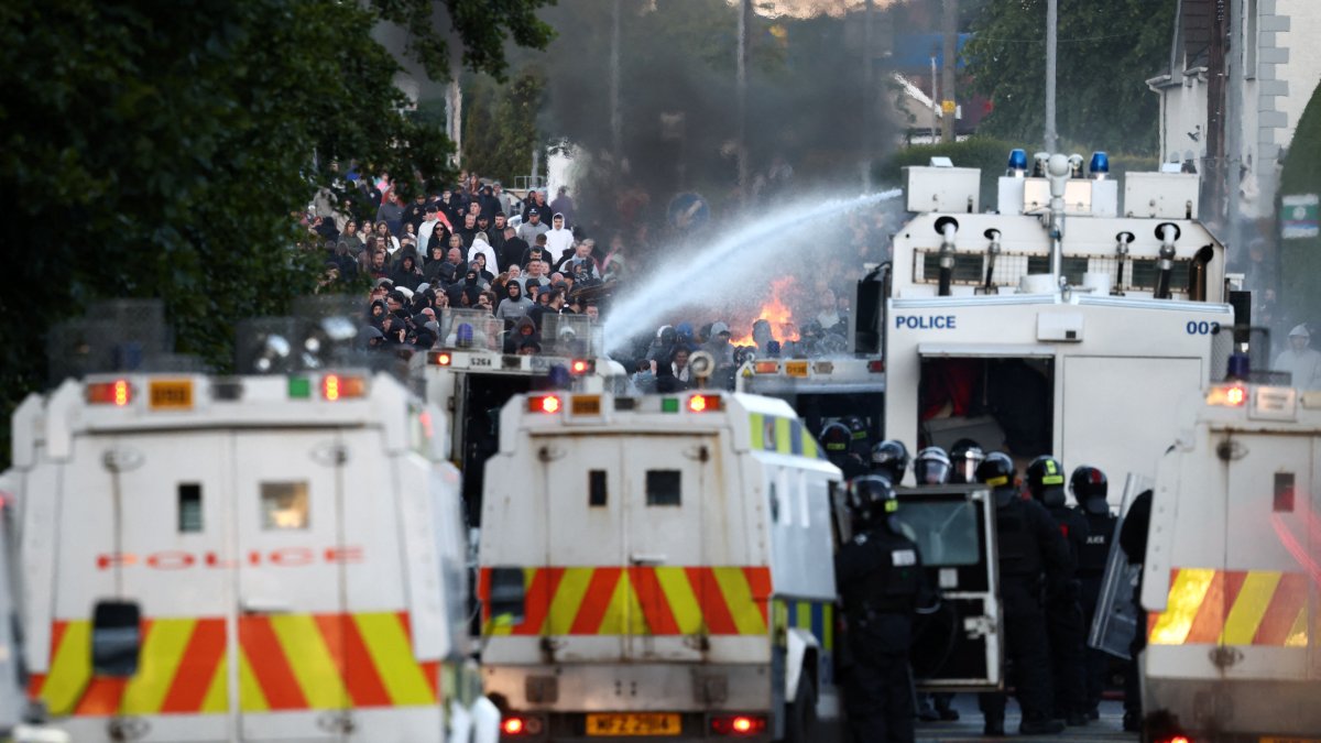 Police use a water cannon while blocking the path of protesters in Glengormley, north of Belfast