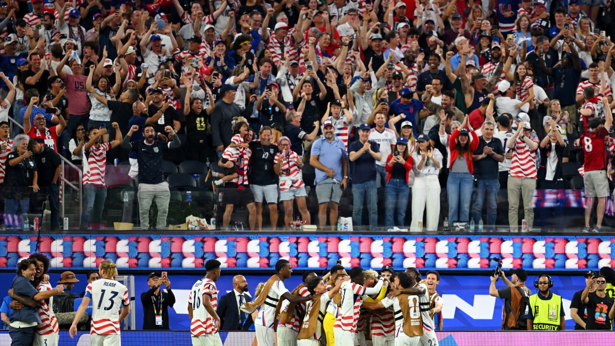 US midfielder #07 Giovanni Reyna celebrates with teammates after scoring his team's fourth goal.