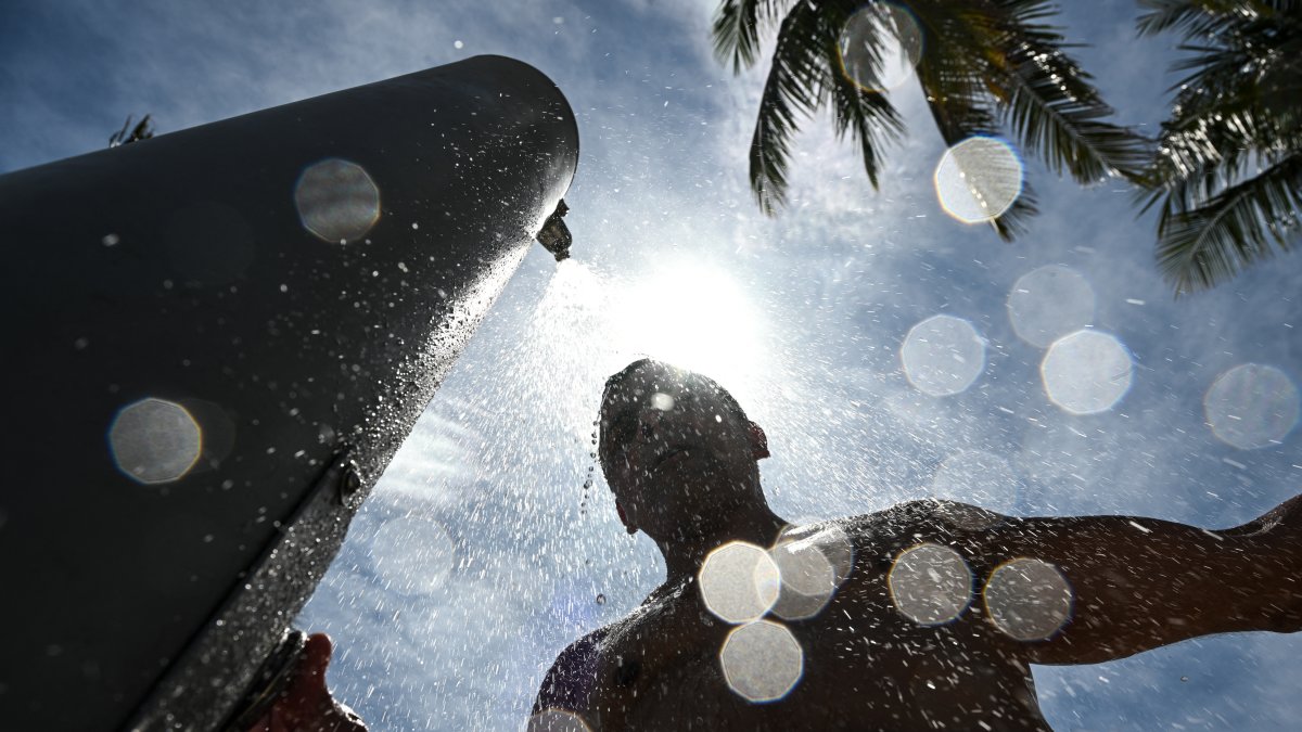 A man takes a shower on a hot afternoon in Miami Beach (File photo)