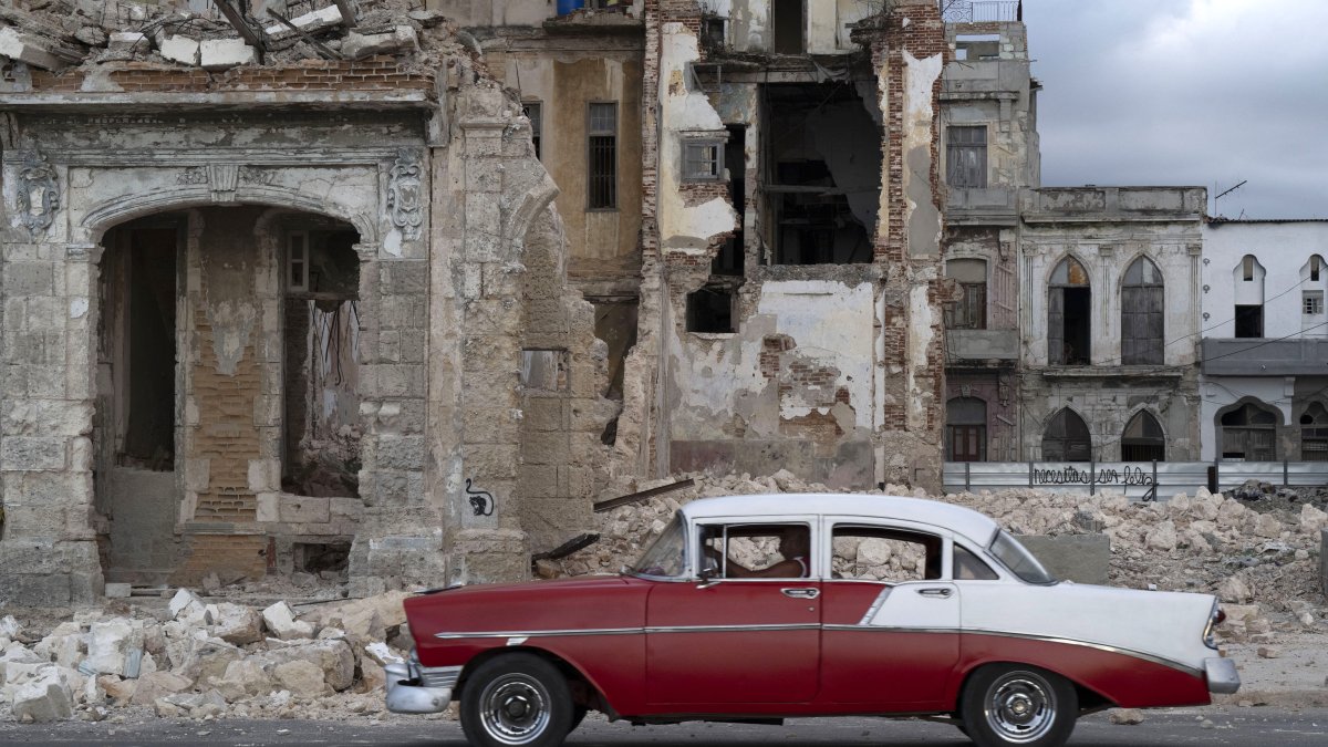 An old car drives past the rubble of a house in Havana (File photo)