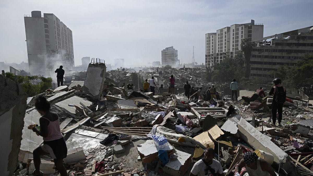 Local residents walk through the rubble after the twin earthquakes that struck Caraballeda, in La Guaira state, about 25 miles northeast of Caracas, on June 25, 2026.